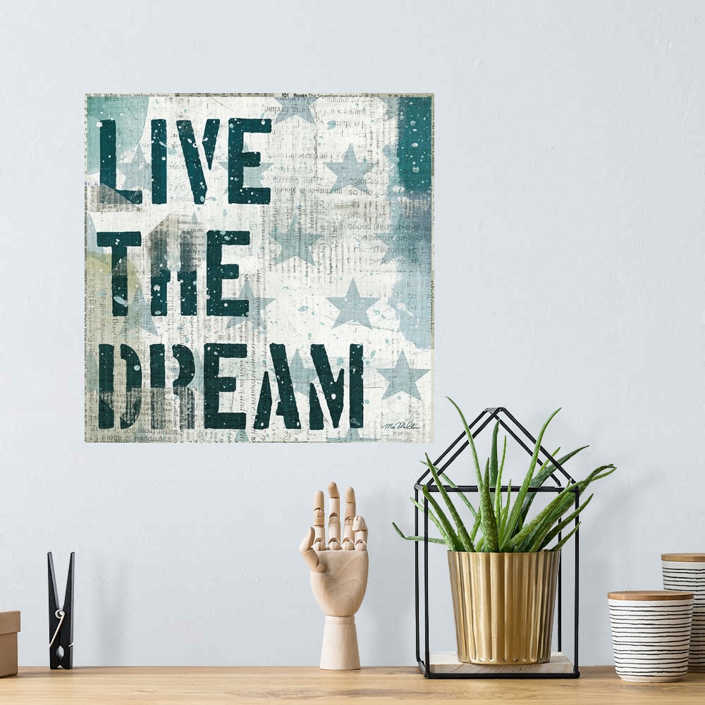 A bohemian room featuring Mixed media artwork of stars and stencil text "Live The Dream," with newspaper print in the backg...