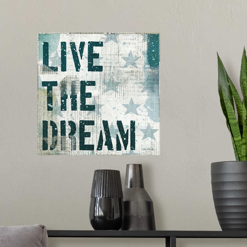 A modern room featuring Mixed media artwork of stars and stencil text "Live The Dream," with newspaper print in the backg...