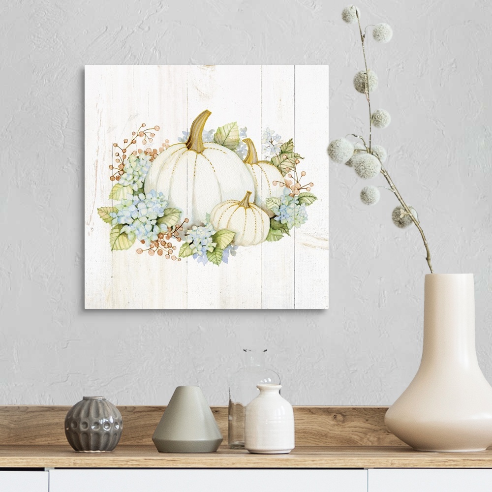 A farmhouse room featuring A square Fall decorative piece with an arrangement of flowers and pumpkins on a white wood panele...