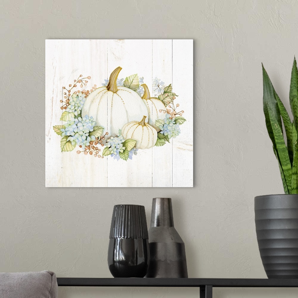 A modern room featuring A square Fall decorative piece with an arrangement of flowers and pumpkins on a white wood panele...