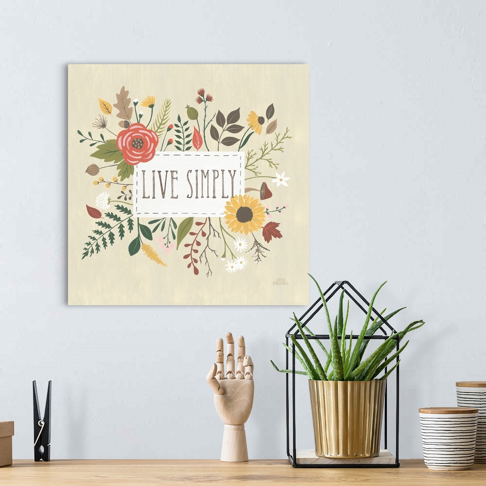 A bohemian room featuring "Live Simply" written in a white rectangle on a light tan background, surrounded by Autumn flowers.