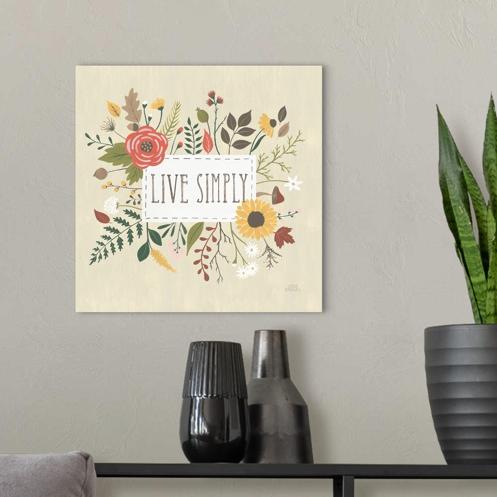 A modern room featuring "Live Simply" written in a white rectangle on a light tan background, surrounded by Autumn flowers.
