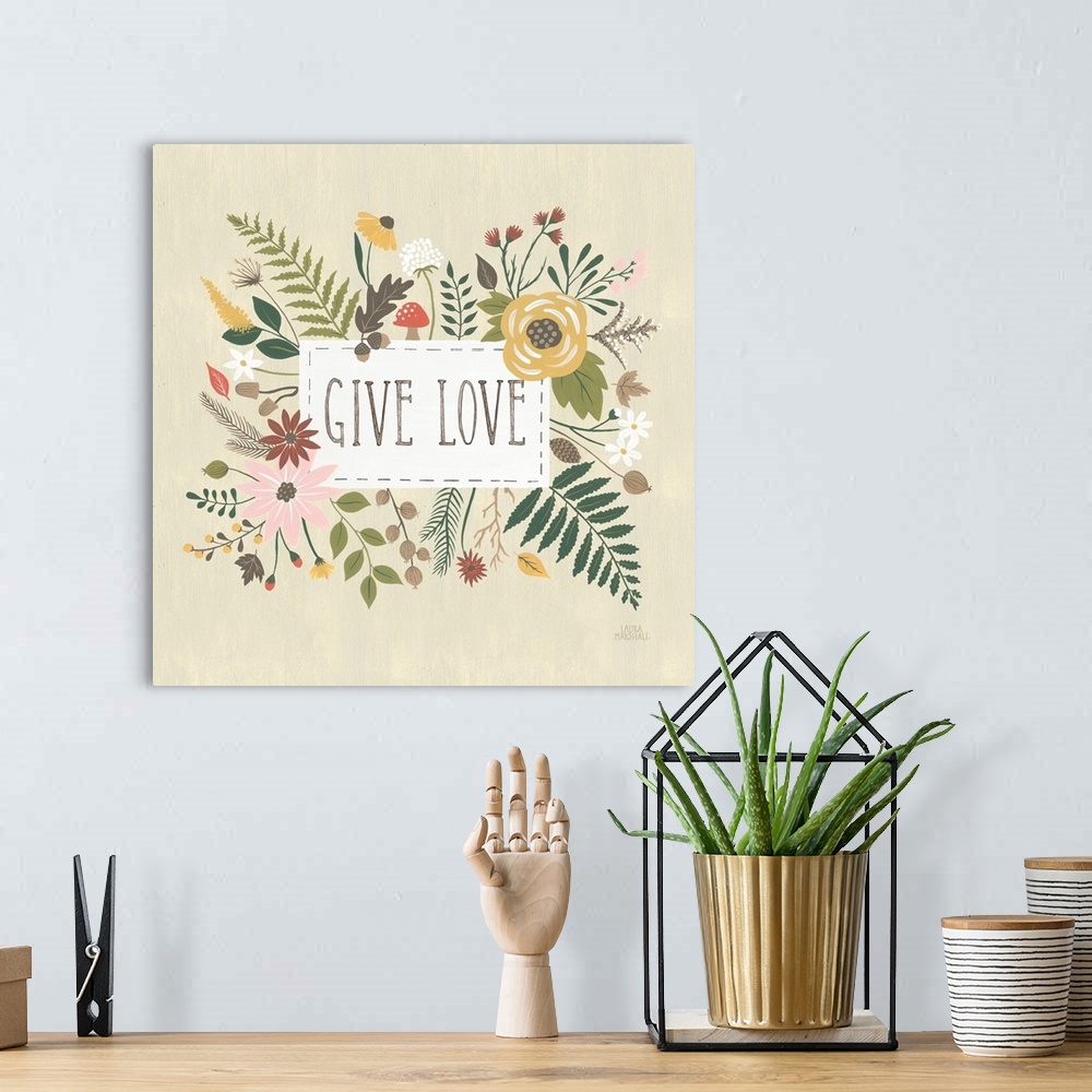 A bohemian room featuring "Give Love" written in a white rectangle on a light tan background, surrounded by Autumn flowers.