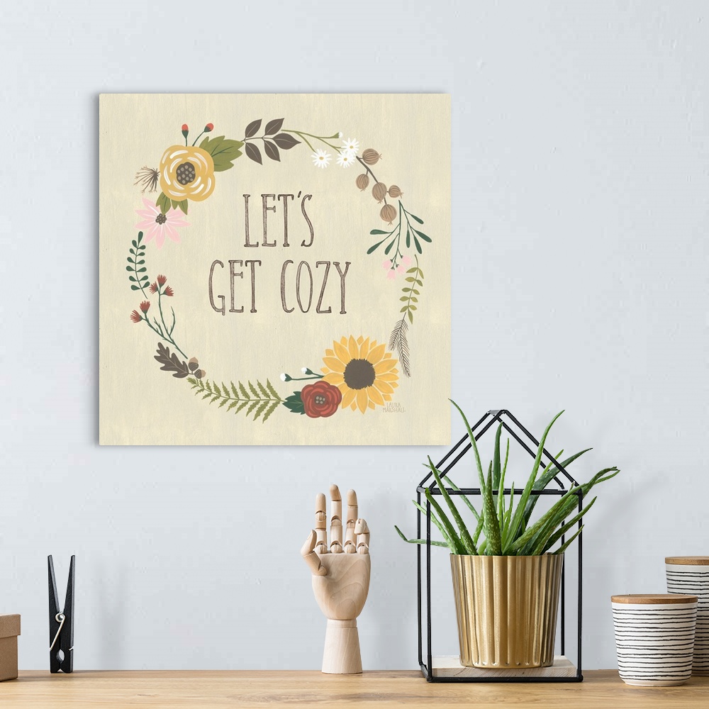 A bohemian room featuring "Let's Get Cozy" in the center of a wreath of autumn flowers on a beige background.