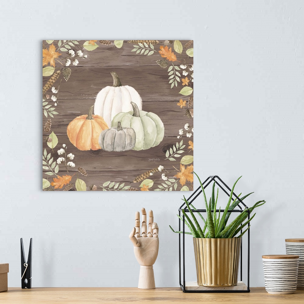 A bohemian room featuring Decorative artwork of fall leaves framing a group of pumpkins and a brown wood background.