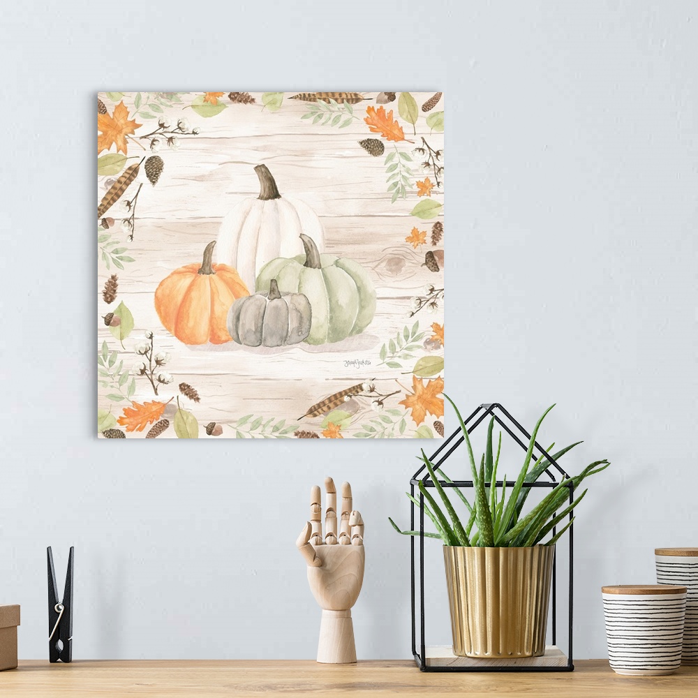 A bohemian room featuring Decorative artwork of fall leaves framing a group of pumpkins and a white wood background.