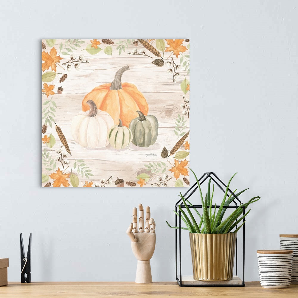 A bohemian room featuring Decorative artwork of fall leaves framing a group of pumpkins and a white wood background.