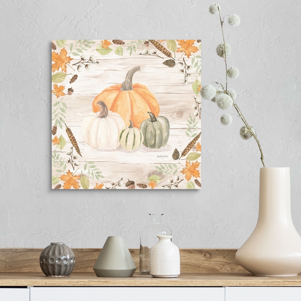 A farmhouse room featuring Decorative artwork of fall leaves framing a group of pumpkins and a white wood background.