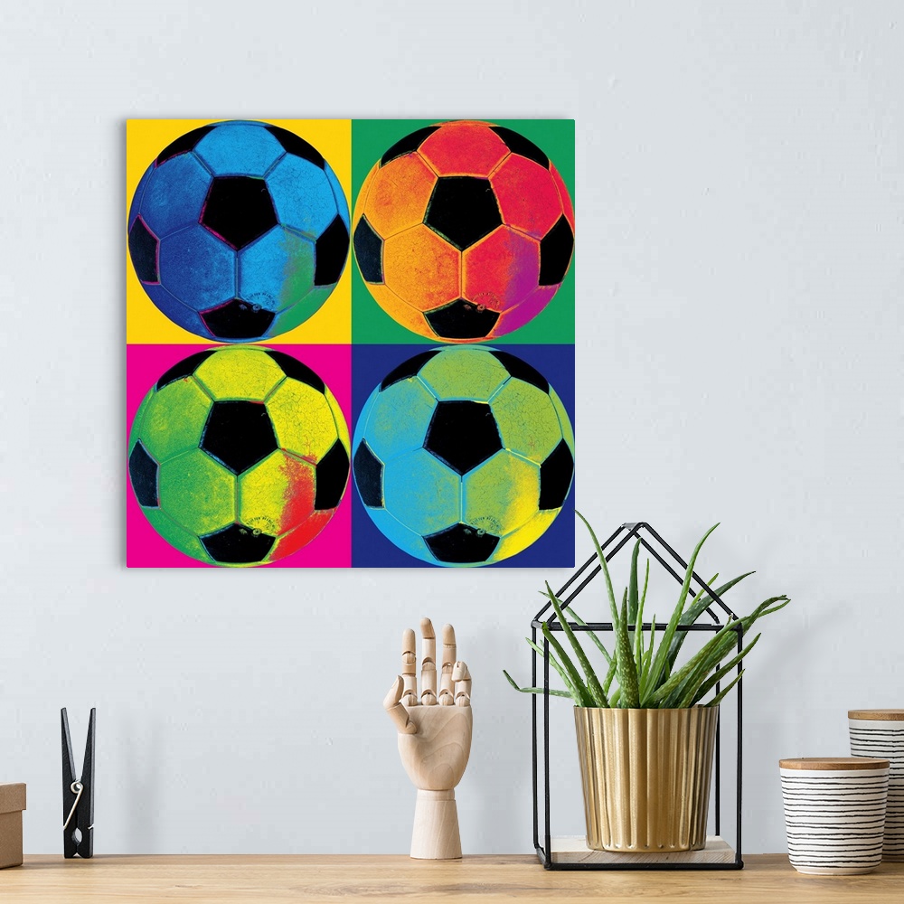 A bohemian room featuring A square canvas of soccer balls of various neon colors in each of the four quadrants with a diffe...