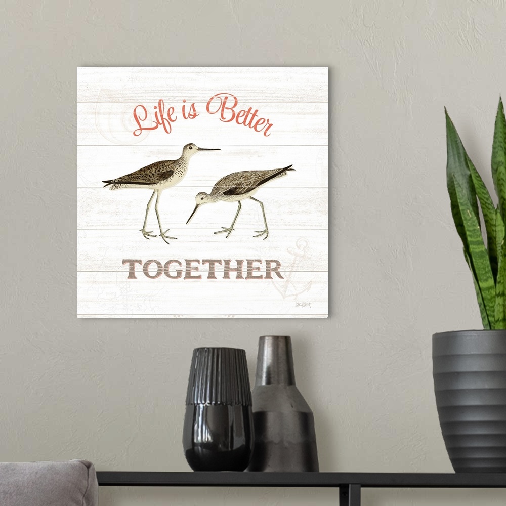 A modern room featuring Square beach decor with "Life is Better Together" written around an illustration of two sandpiper...