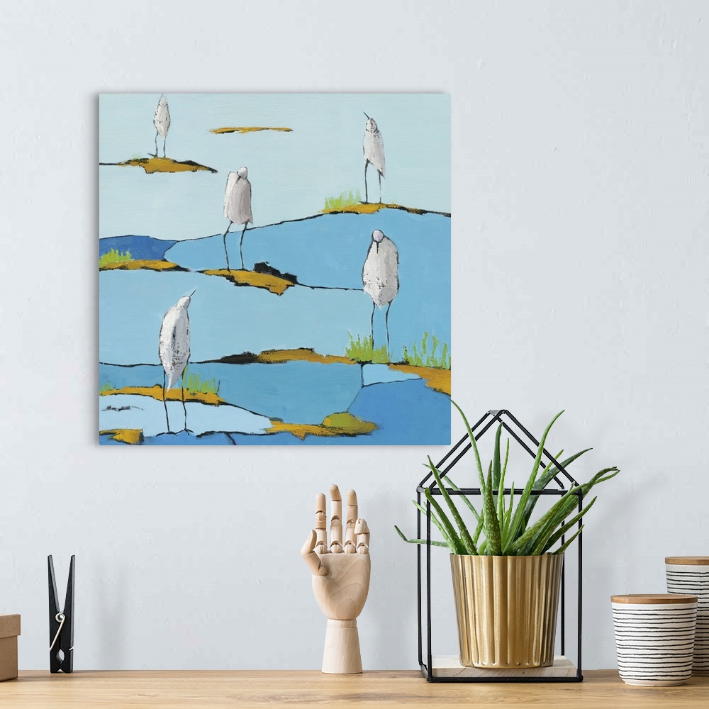 A bohemian room featuring Square abstract painting of five white egrets relaxing on a blue and gold patterned marsh.