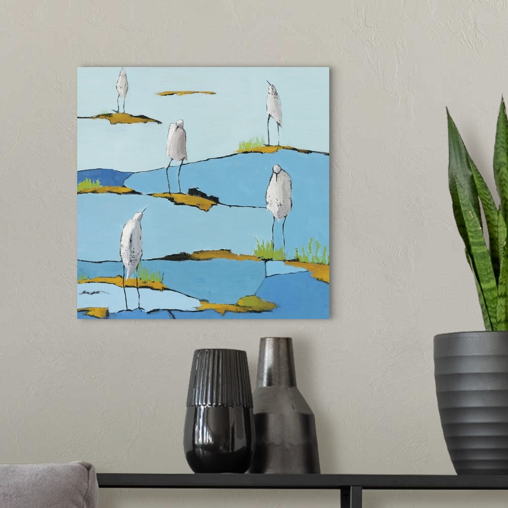 A modern room featuring Square abstract painting of five white egrets relaxing on a blue and gold patterned marsh.