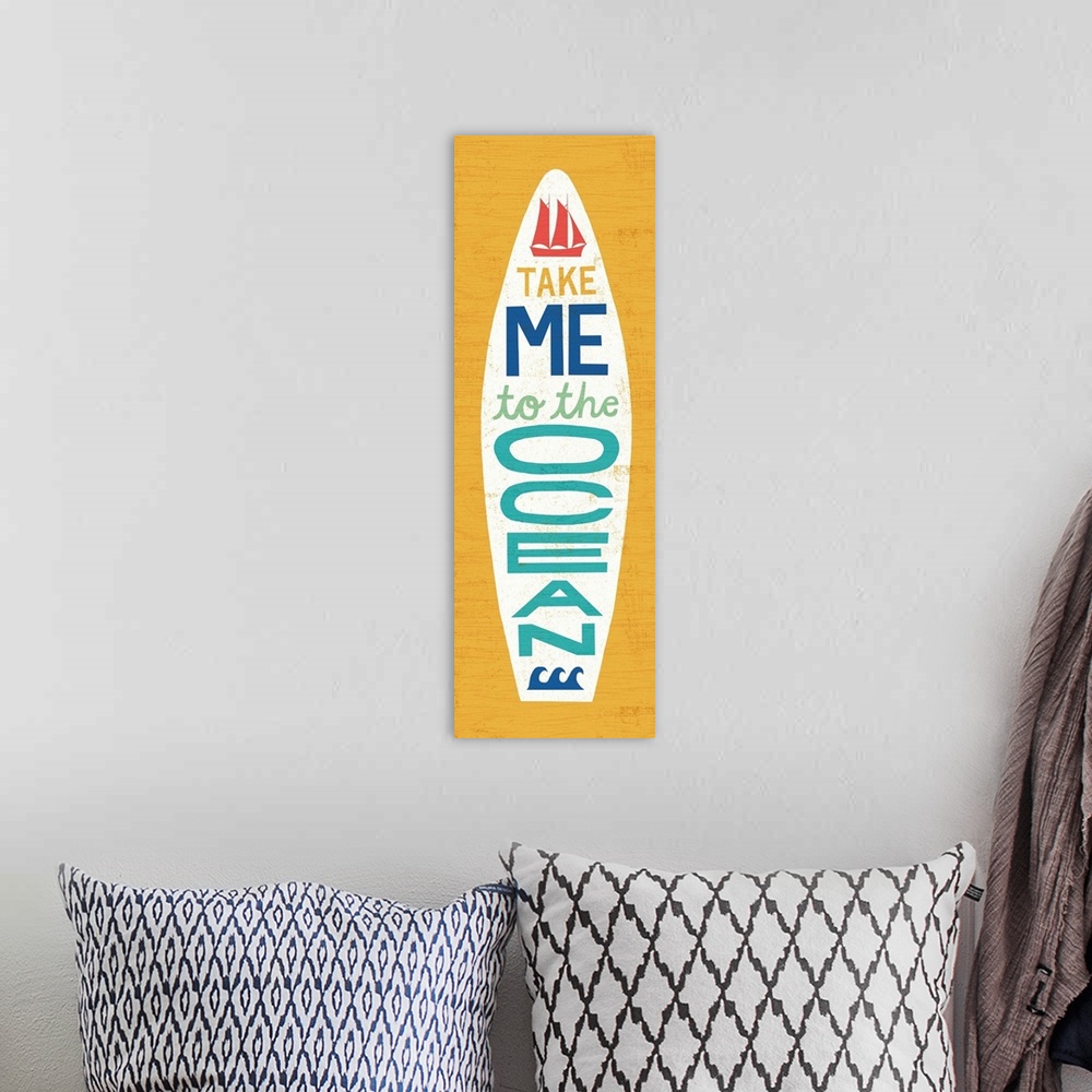 A bohemian room featuring "Take Me to the Ocean" surfboard decorated with a sailboat and waves on a yellow background.