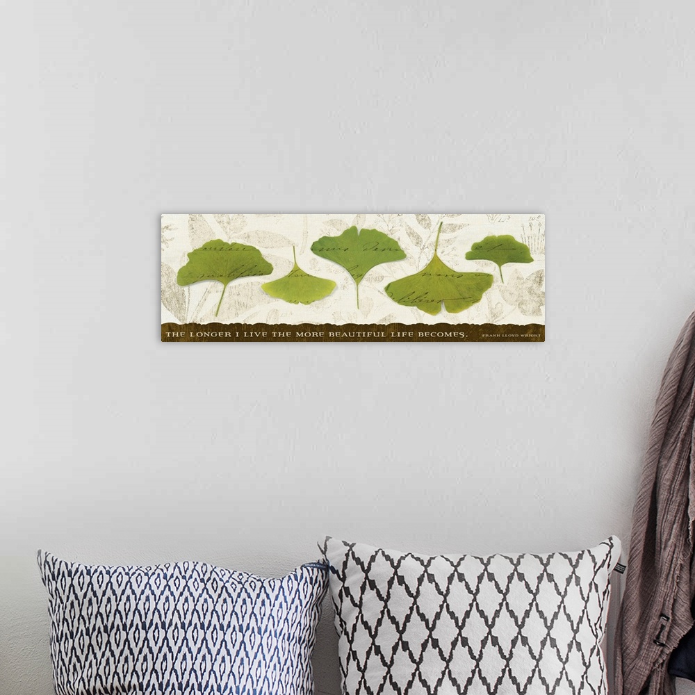 A bohemian room featuring Big, horizontal wall hanging of five green leaves with scripted text running through them, on a n...