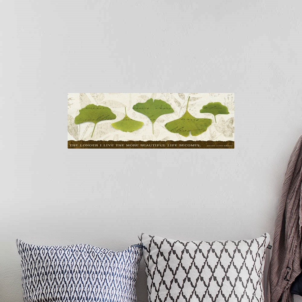 A bohemian room featuring Big, horizontal wall hanging of five green leaves with scripted text running through them, on a n...