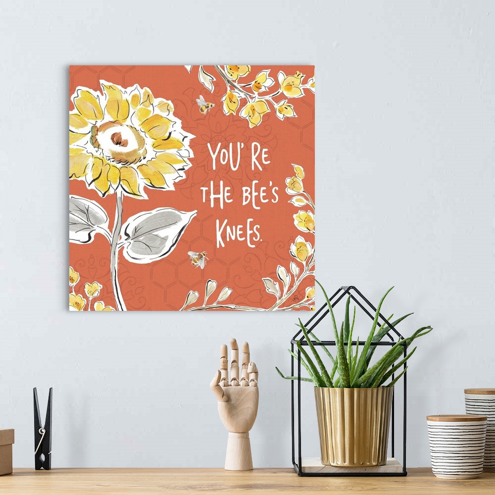 A bohemian room featuring "You're The Bee's Knees" written in white on a dark coral colored background with illustrations o...