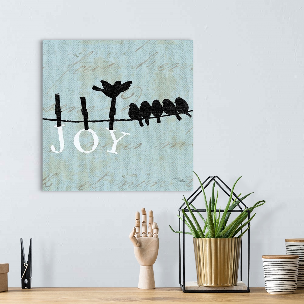 A bohemian room featuring Contemporary artwork of birds silhouetted on a cloths line, with the word "JOY" hanging from the ...