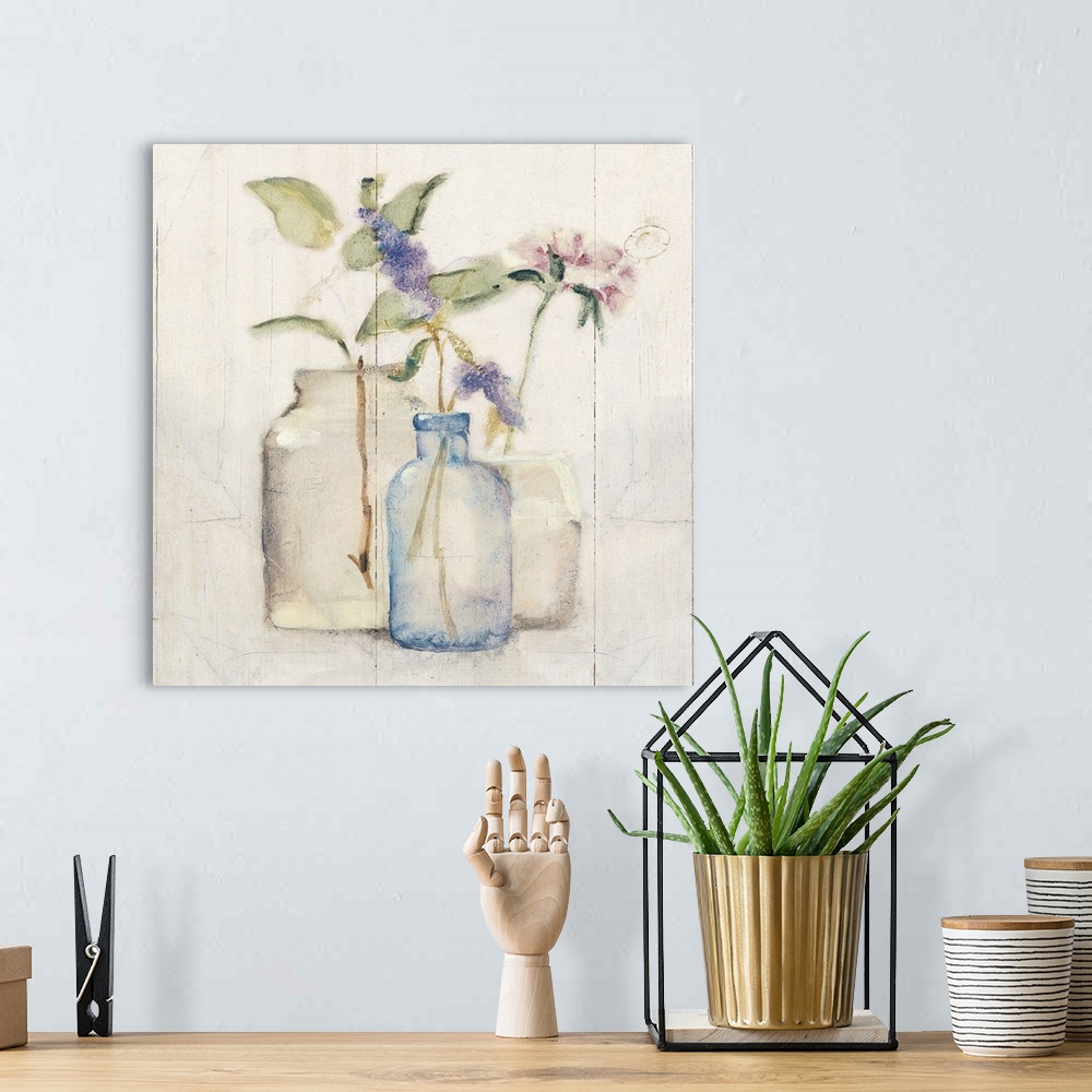 A bohemian room featuring Square artwork with flowers in glass vases on a rustic shiplap background.