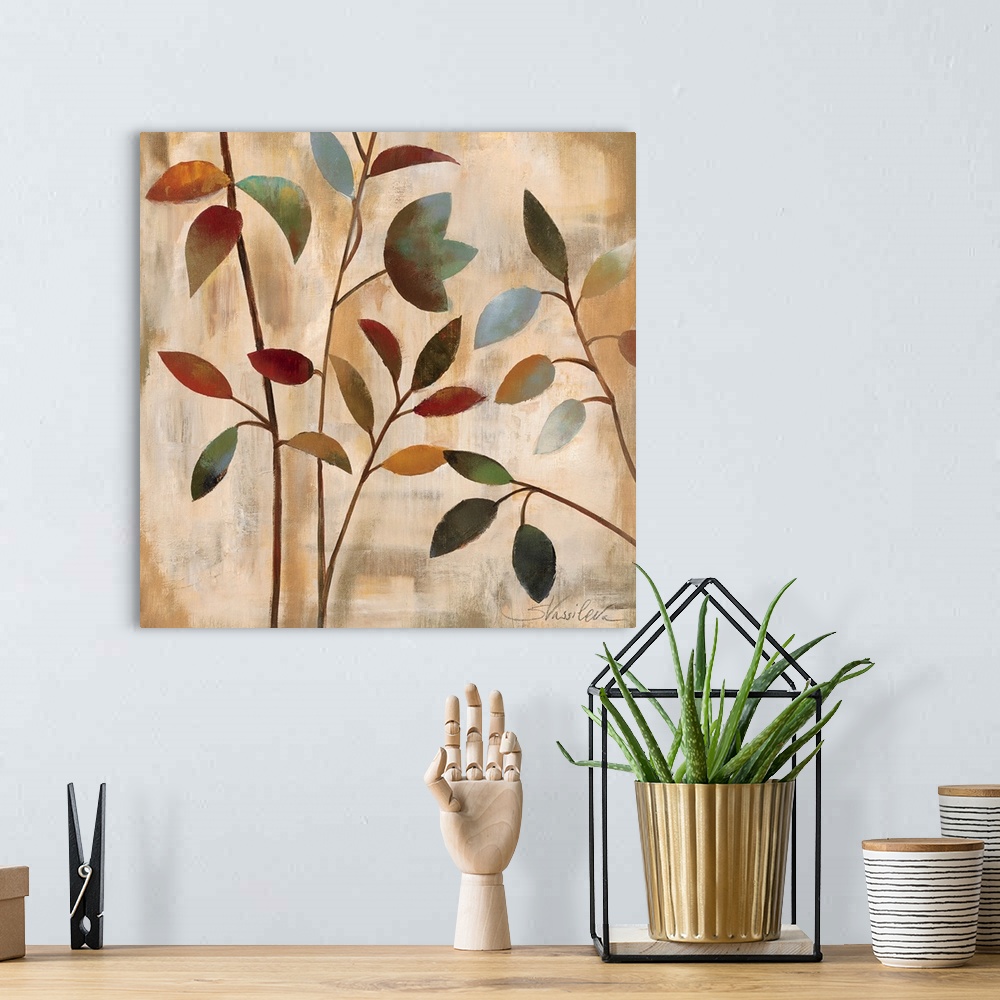 A bohemian room featuring Docor artwork of four thin branches with colorful leaves on a textured, neutral background.