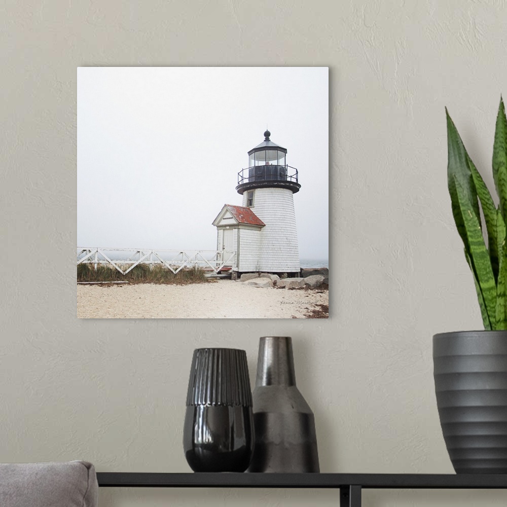 A modern room featuring A square photograph of the Brant Point Lighthouse in Nantucket Island, Massachusetts, blanketed i...