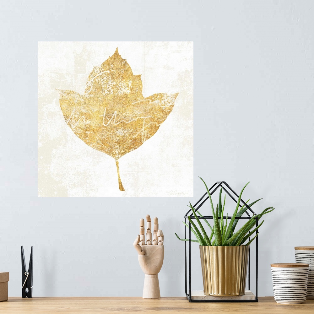 A bohemian room featuring Gold silhouette of a leaf with white writing.