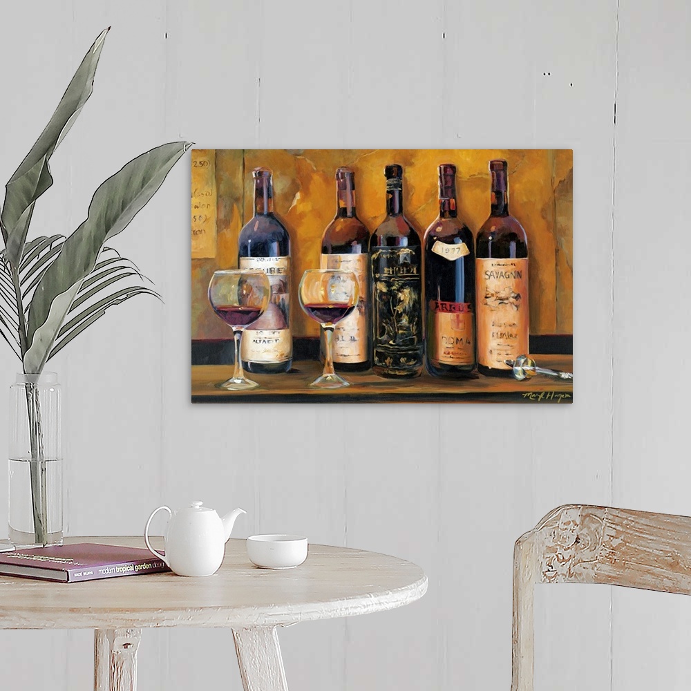 A farmhouse room featuring Landscape wall painting of five bottles of red wine with two full wine glasses sitting on a count...