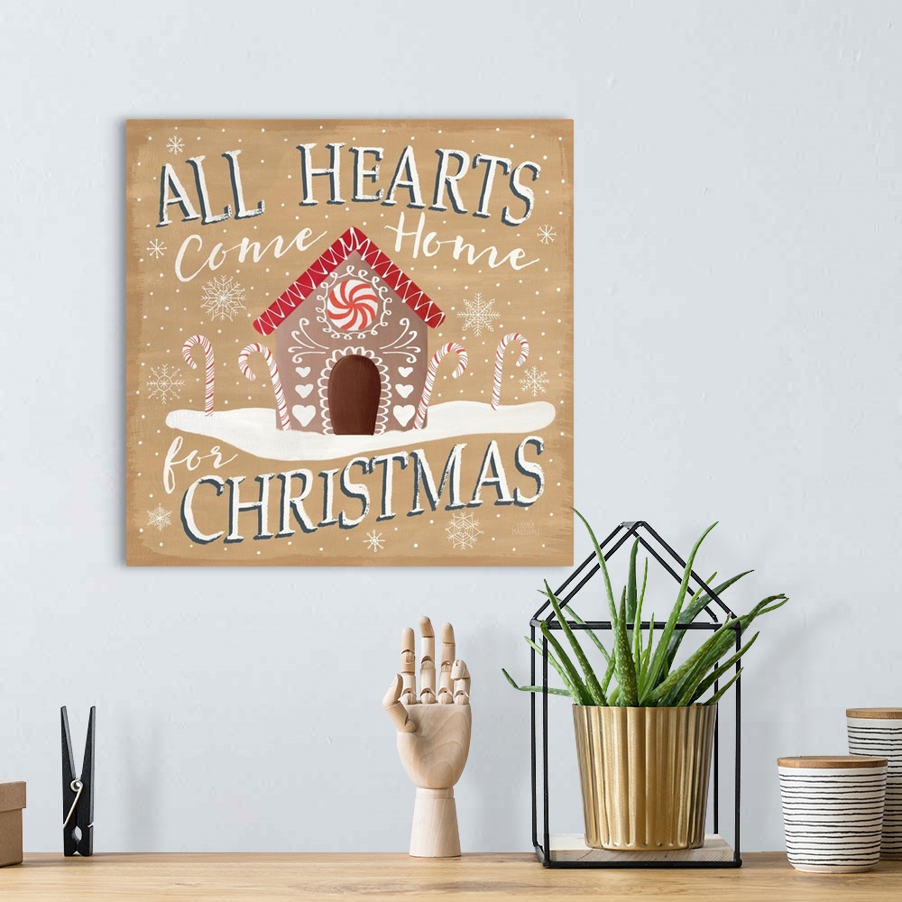 A bohemian room featuring Square decorative artwork of a gingerbread house with the text "All Hearts Come Home for Christma...