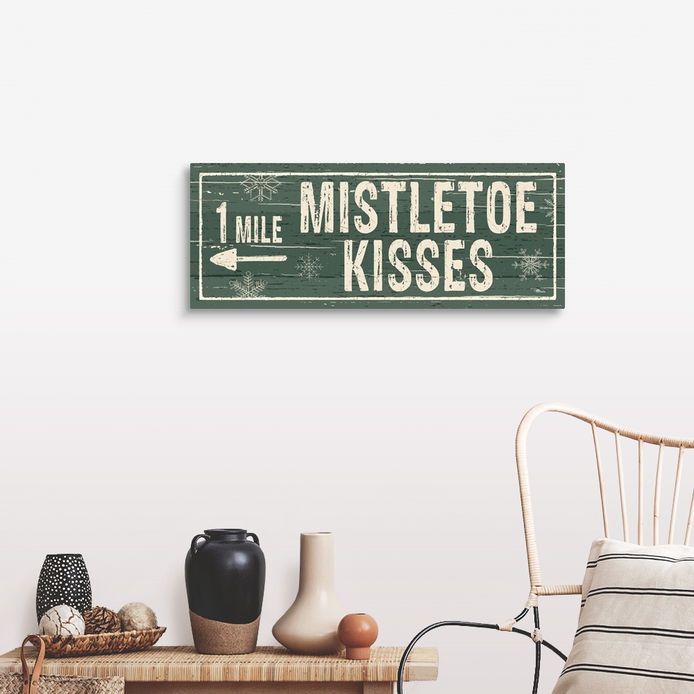 A farmhouse room featuring Decorative artwork with a holiday theme with the text "1 Mile Mistletoe Kisses" on a green backdrop.