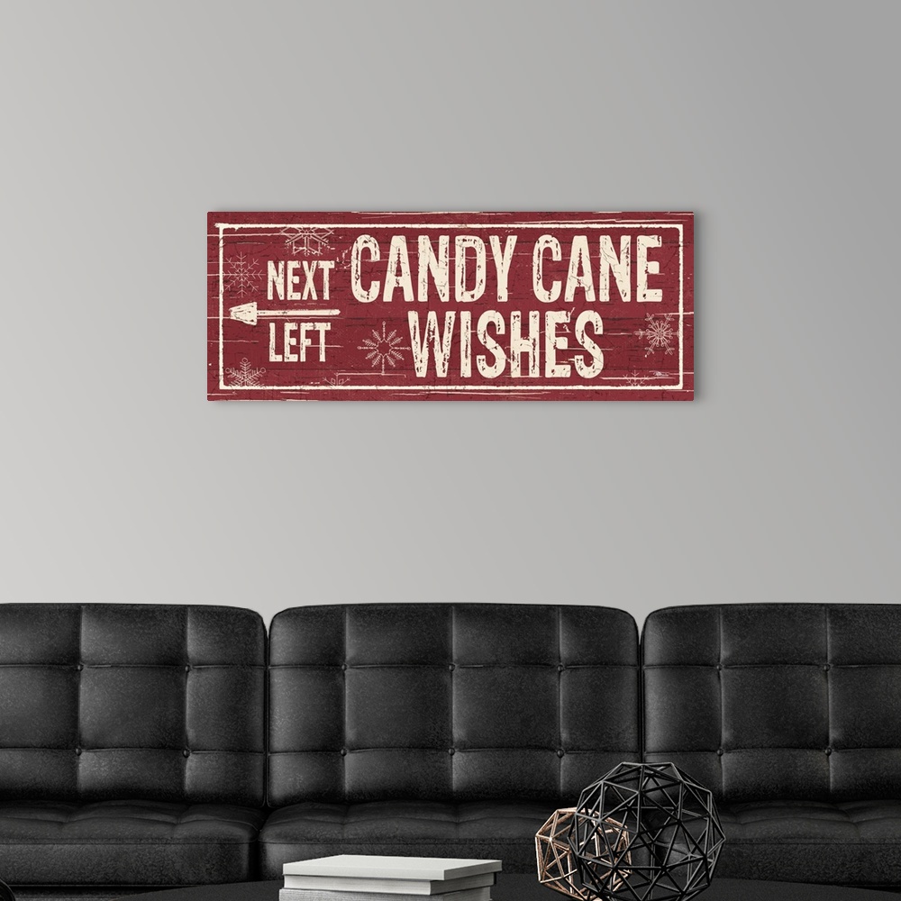 A modern room featuring Decorative artwork with a holiday theme with the text "Next Left Candy Cane Wishes" on a red back...