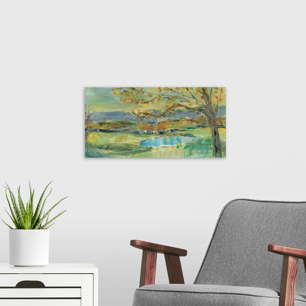 A modern room featuring A large horizontal landscape of a pond in a field with a tree in the foreground.