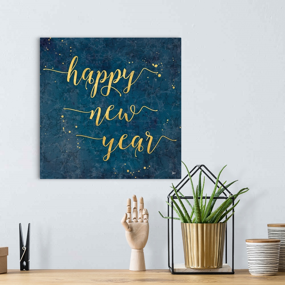 A bohemian room featuring Decorative square artwork of a marbled blue background with the text "happy new year" in gold wit...