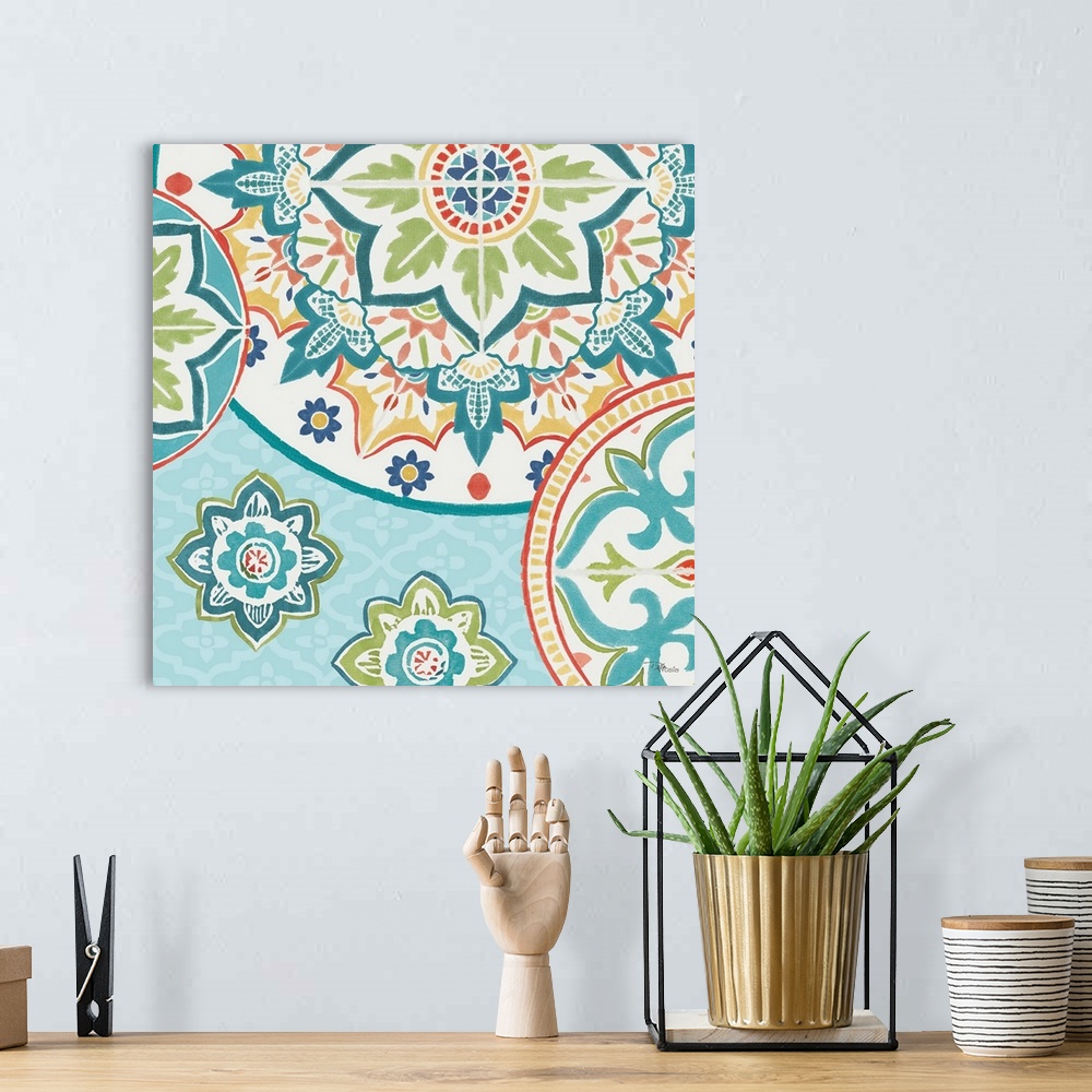 A bohemian room featuring Square artwork of a floral tile design in cool colors of blue, green and red.