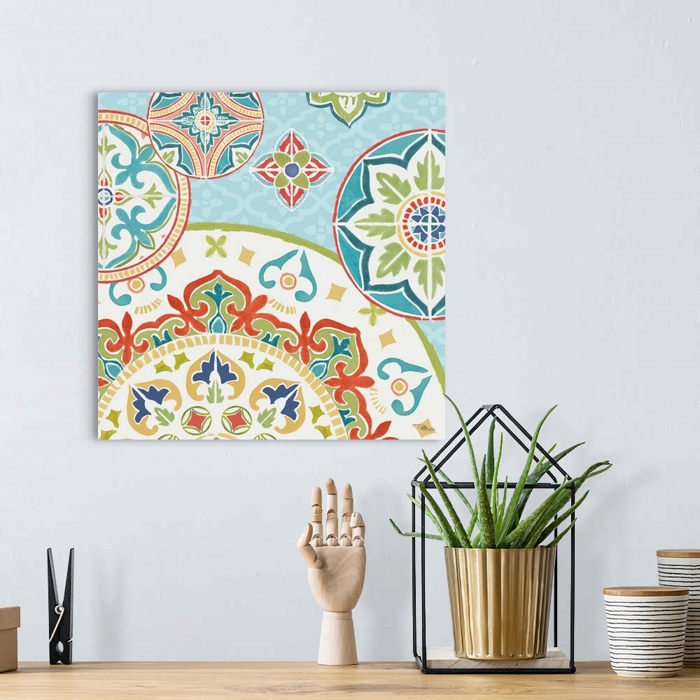 A bohemian room featuring Square artwork of a floral tile design in cool colors of blue, green and red.