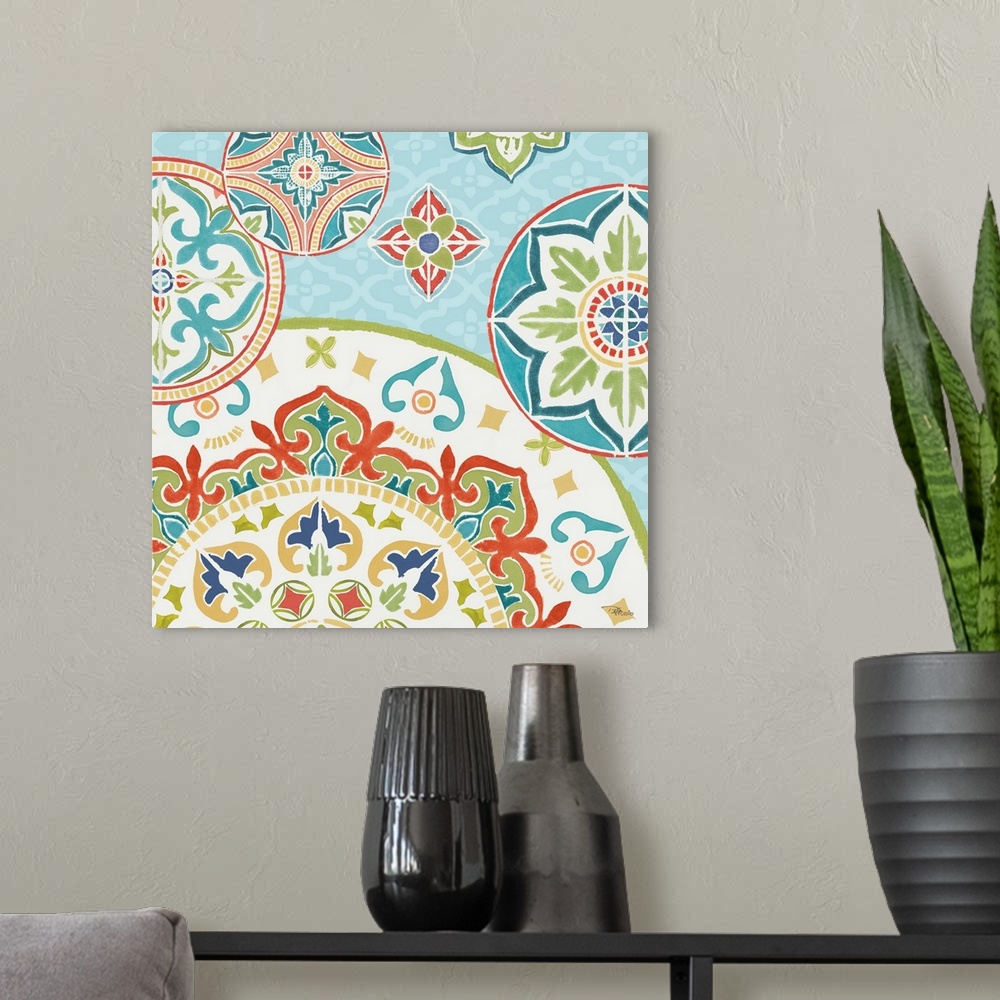 A modern room featuring Square artwork of a floral tile design in cool colors of blue, green and red.