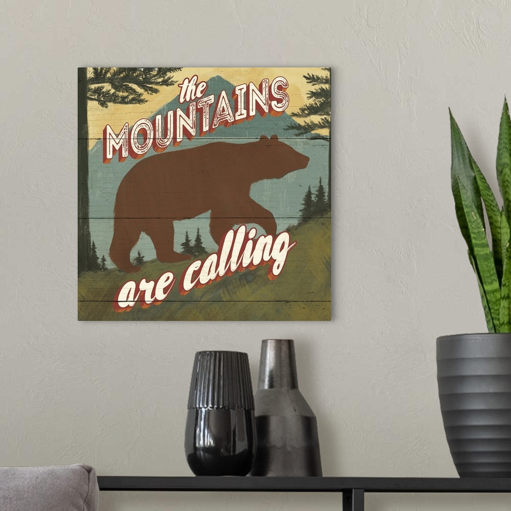A modern room featuring "The mountains are calling" over a minimalist image of a bear in the wilderness.