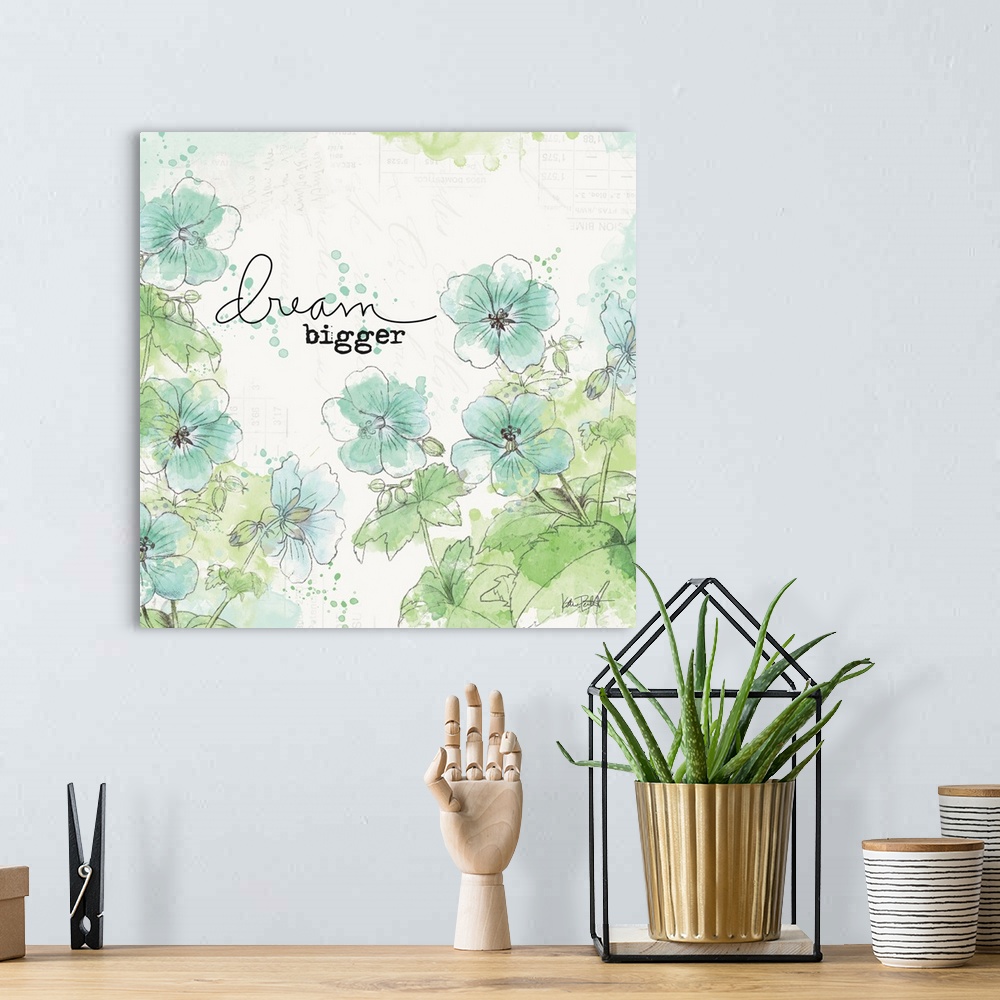 A bohemian room featuring "Dream Bigger" square art with illustrated blue and green flowers on a  white background with fai...