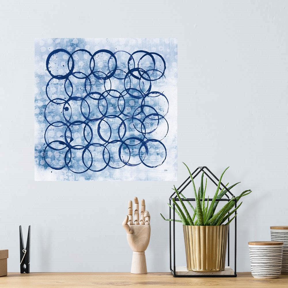 A bohemian room featuring Square abstract painting with indigo outlines of circles overlapping in the foreground and smalle...
