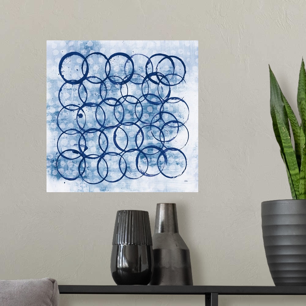 A modern room featuring Square abstract painting with indigo outlines of circles overlapping in the foreground and smalle...