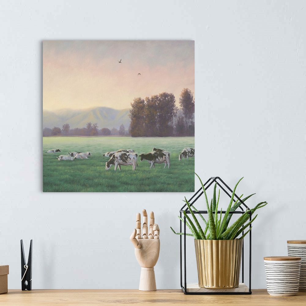 A bohemian room featuring Square painting of a rural farm scene with grazing cows and mountains in the background.