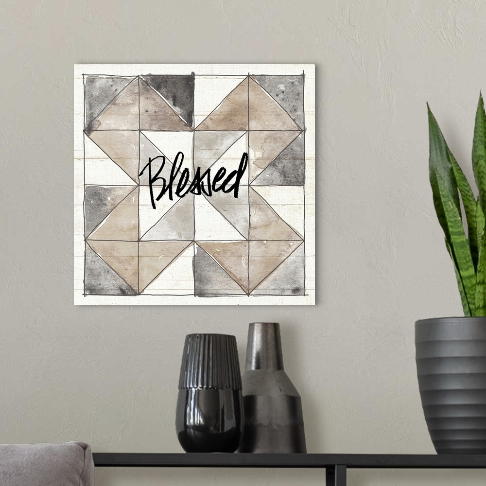 A modern room featuring "Blessed" with a watercolor quilt box design in neutral colors on a wood panel backdrop.