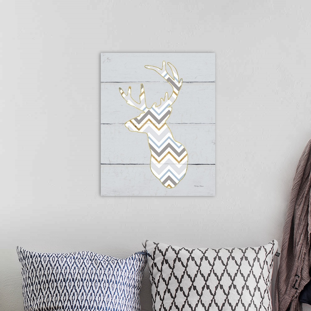 A bohemian room featuring A decorative design of a deer silhouette in a chevron pattern and gold accents on a grey wood pan...