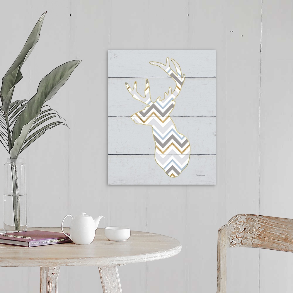 A farmhouse room featuring A decorative design of a deer silhouette in a chevron pattern and gold accents on a grey wood pan...
