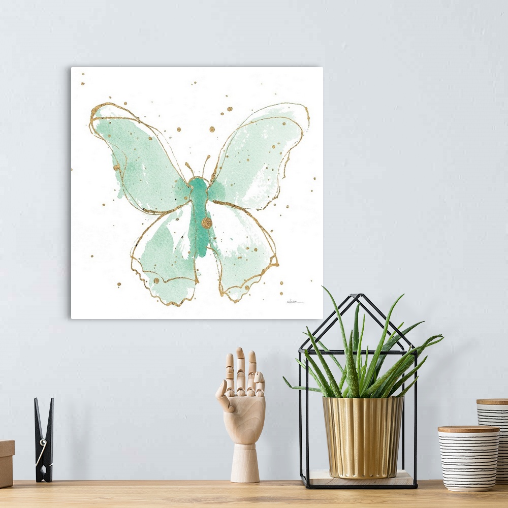 A bohemian room featuring A square watercolor painting of a mint green butterfly outlined in gold with gold splatters.