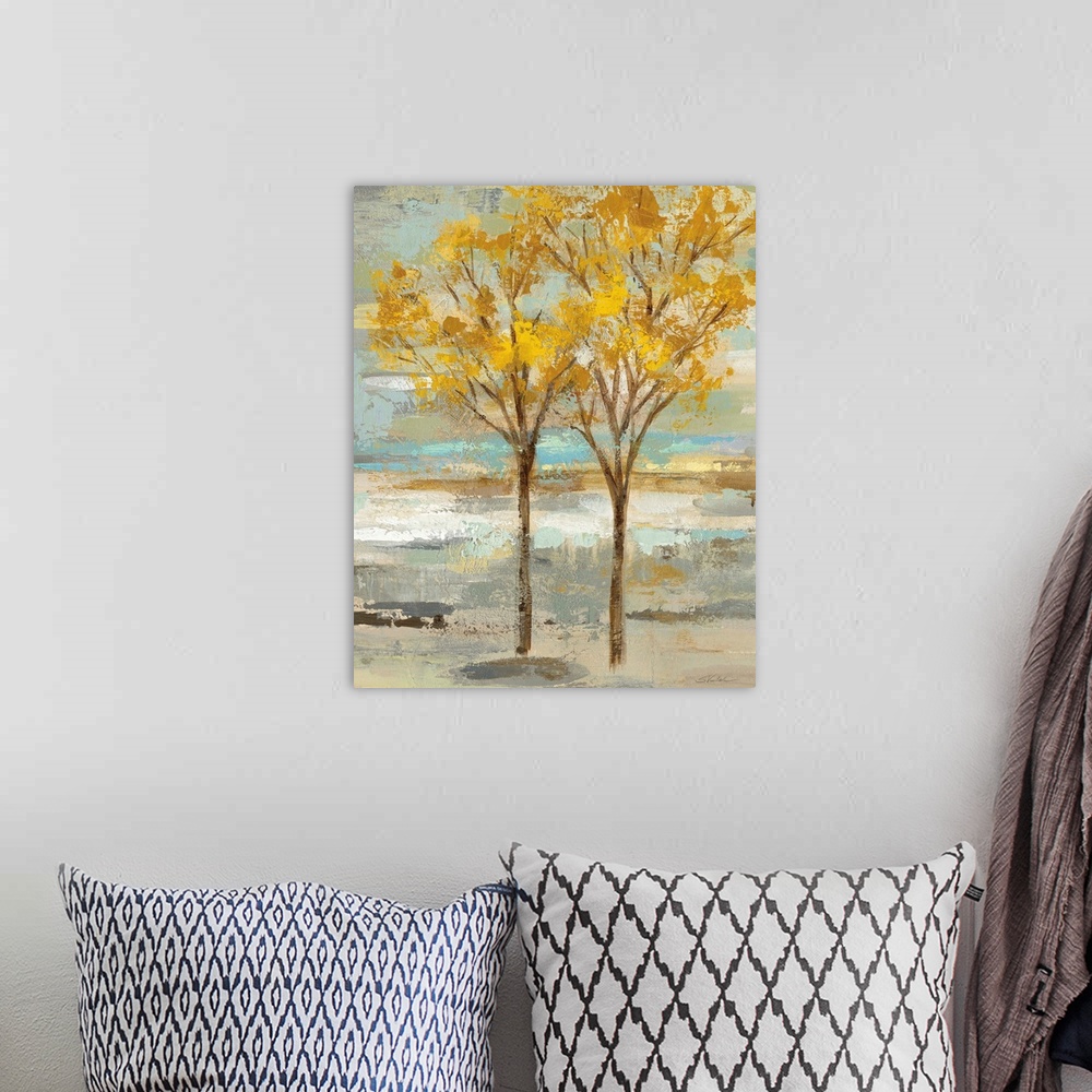 A bohemian room featuring Abstract painting of two golden leafed trees on a colorful background made up of blue, green, tan...
