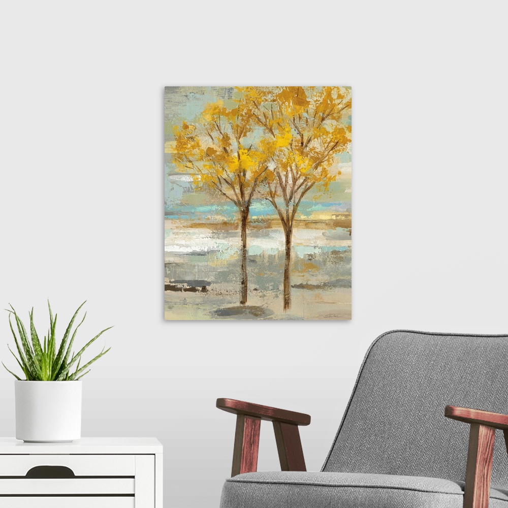 A modern room featuring Abstract painting of two golden leafed trees on a colorful background made up of blue, green, tan...