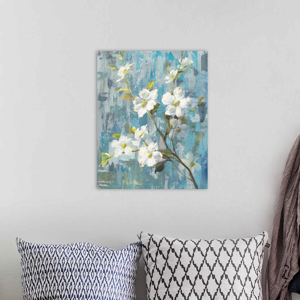 A bohemian room featuring Decorative artwork of white blooming flowers on a branch with a textured blue background.