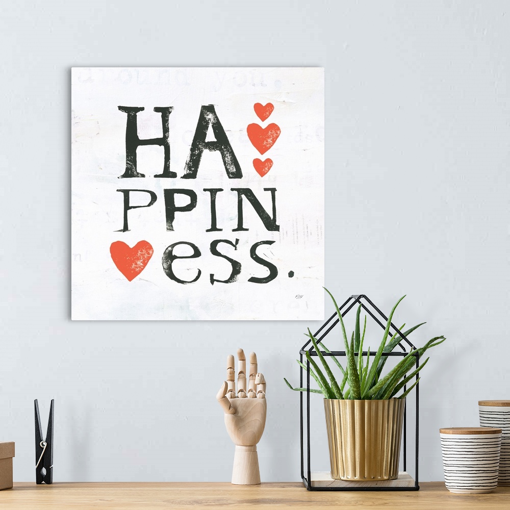 A bohemian room featuring Square painting with the word "happiness" written in three lines with red hearts on a white backg...