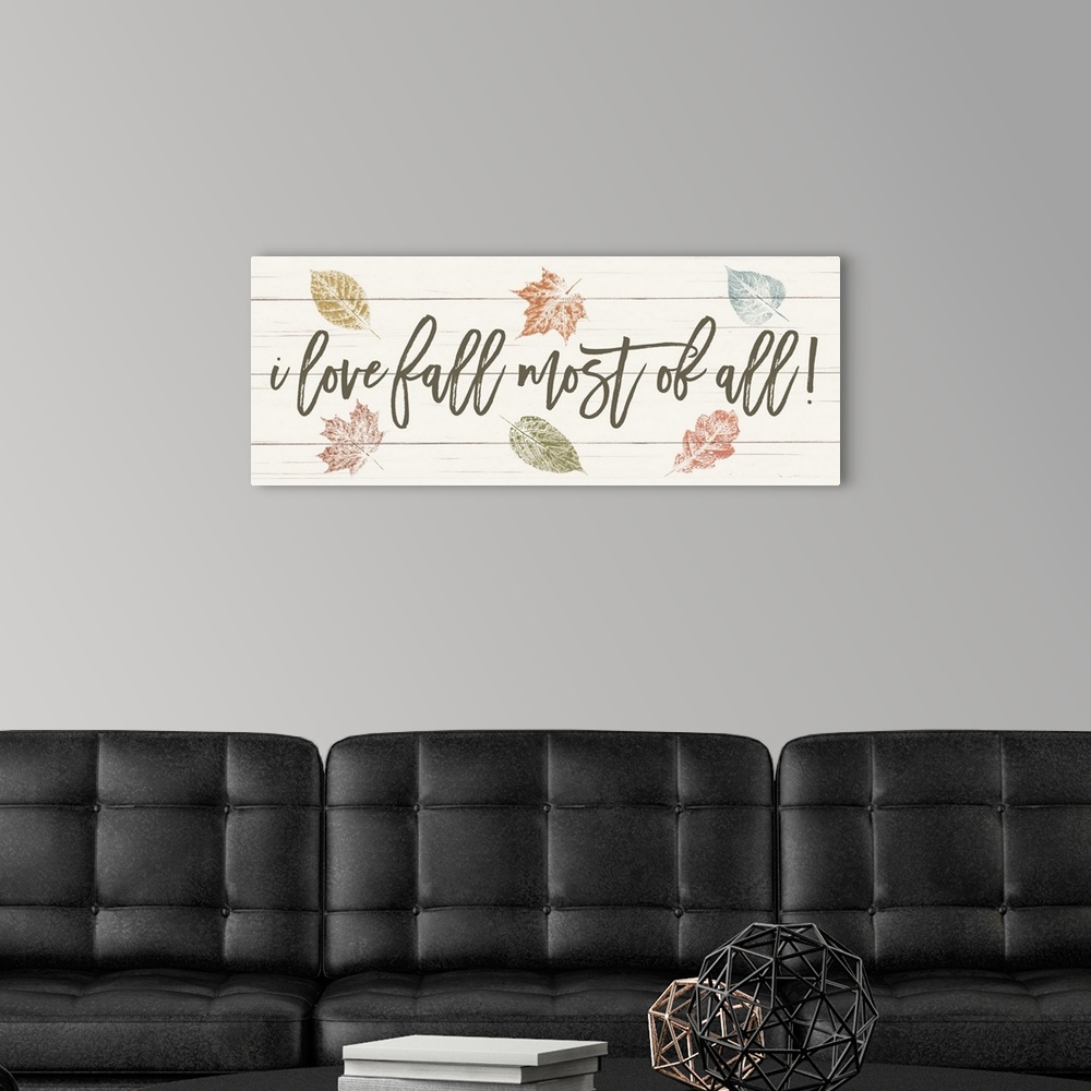 A modern room featuring "i love fall most of all!" on a white wood plank background with fall leaves.