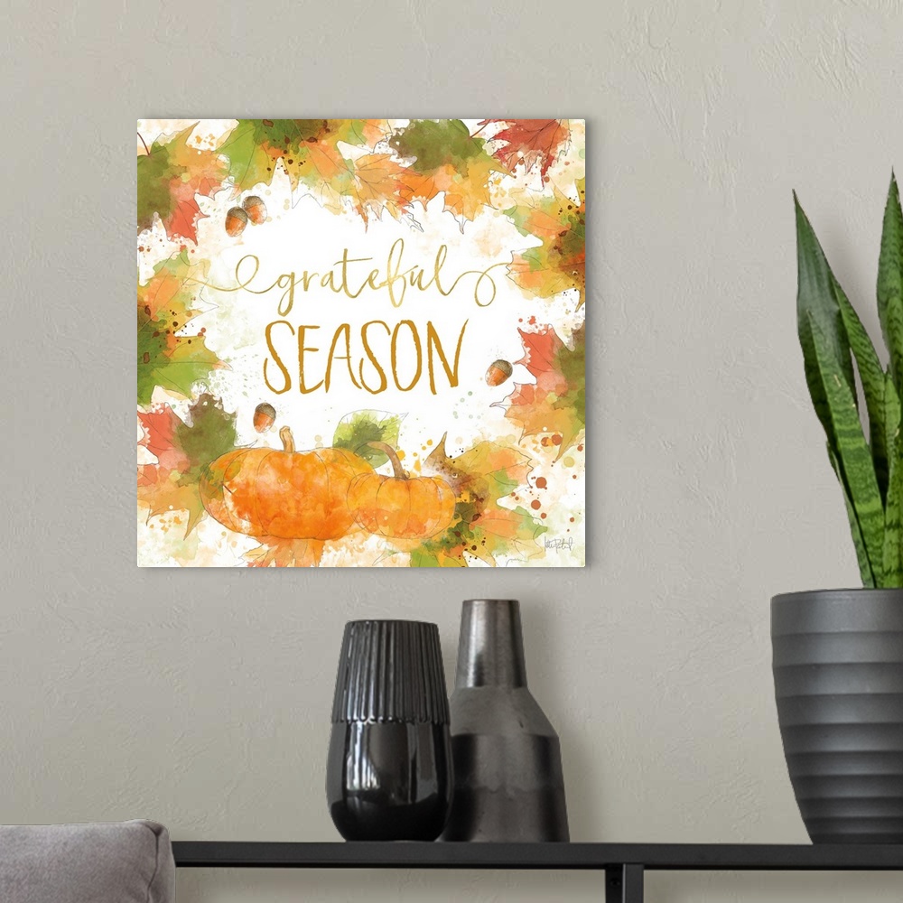 A modern room featuring "Grateful Season" written inside a harvest wreath with Fall leaves, acorns, and pumpkins.