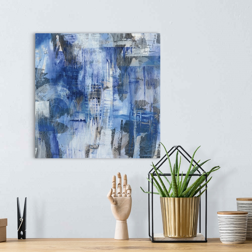 A bohemian room featuring Square abstract painting with blue, gray, and white hues creating different shapes and layers of ...